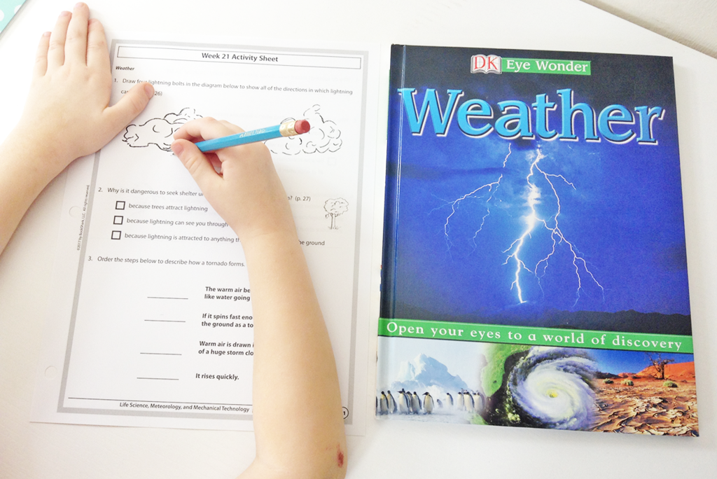 weather-activitysheet BookShark Science • a child studying weather with a book and activity sheet